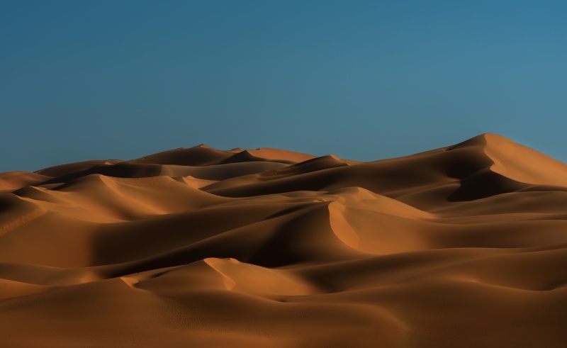 Dune désert photo HD couleur ambre sur ciel bleu