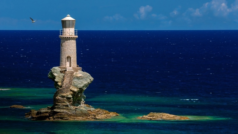 Phare sur rocher bord de mer bleu